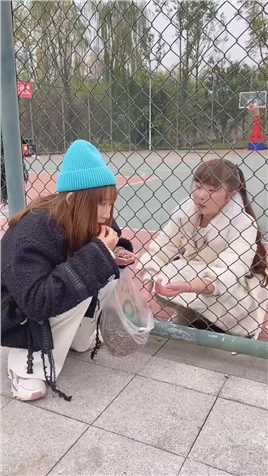 篮球场一女子为了吃瓜子，结果因智商问题，被墙网锁住双手！